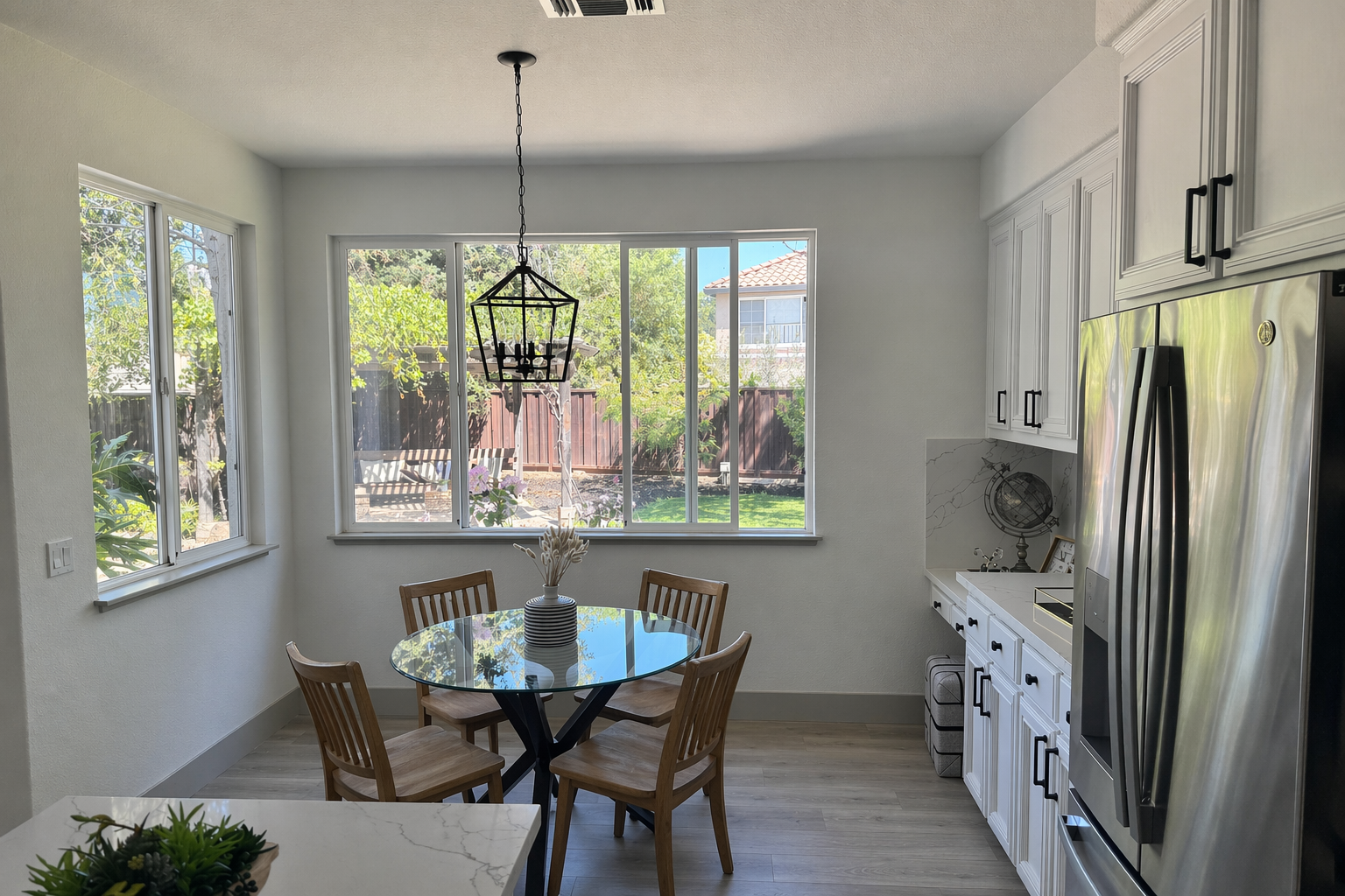 In this room photo, replace ONLY the white chairs with chairs made of wood. Preserve camera angle, room lighting, floor shadows, and surrounding objects. Keep all other aspects of the image unchanged. Photorealistic contact shadows and fabric texture.